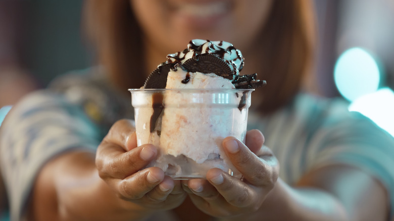 Person holding fast food ice cream outstretched