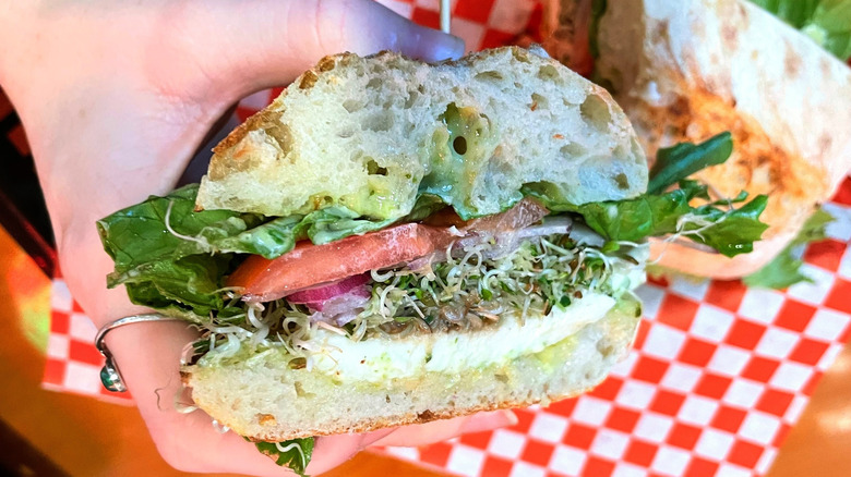 Veggie sandwich half held by a hand
