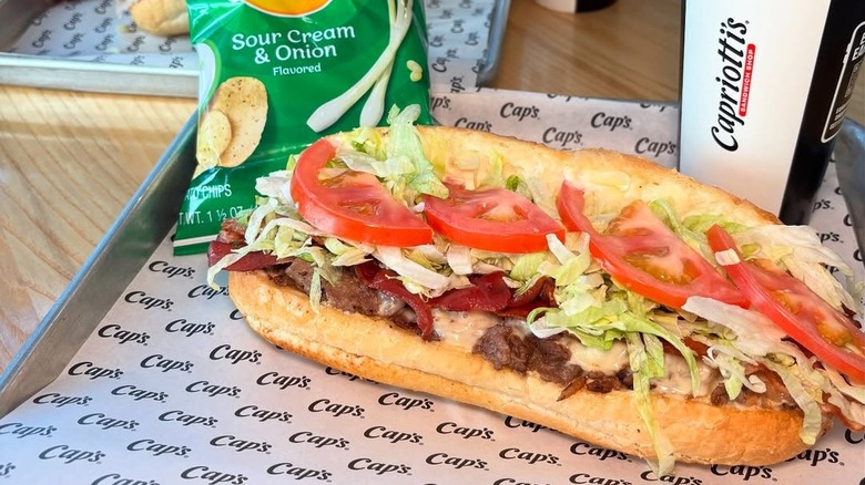 a Capriotti's sandwich with a drink and bag of chips