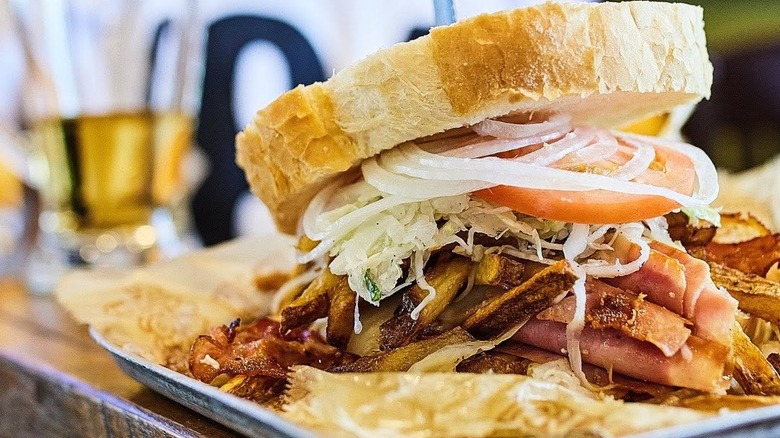 a Primanti Bros. sandwich with lettuce, onion, bacon, and fries