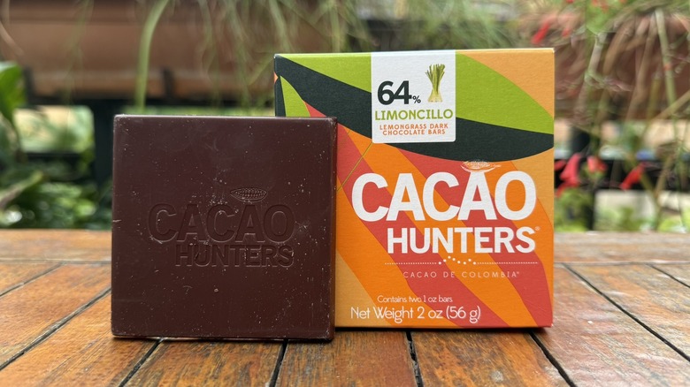 Large square of lemongrass chocolate standing next to packaging on wooden table