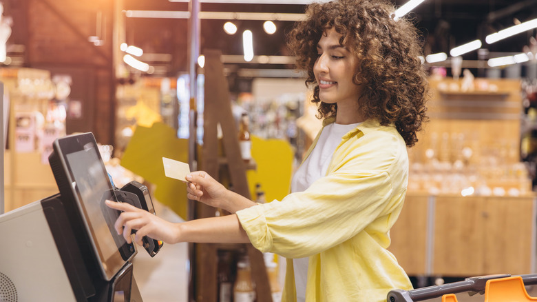 Customer paying with a card at a self-checkout station