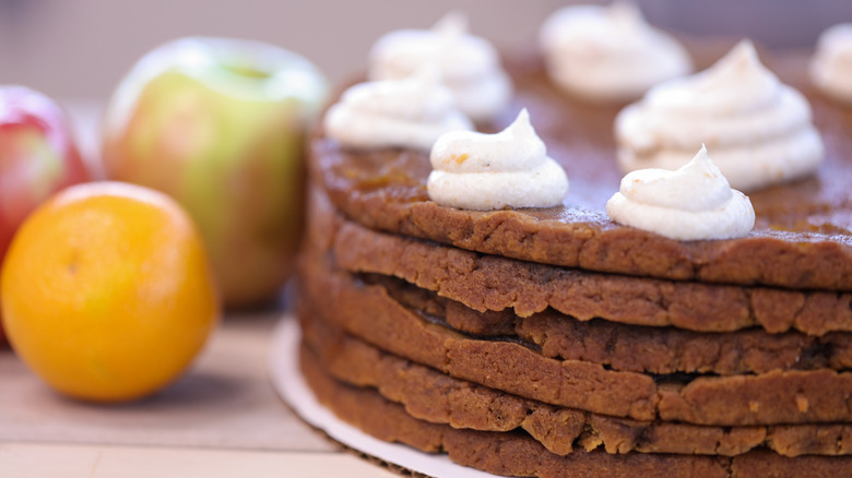 Apple and ginger spice stack cake with orange and apples in background