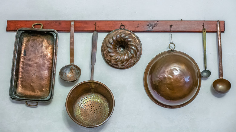 Vintage copper molds hanging on a rack
