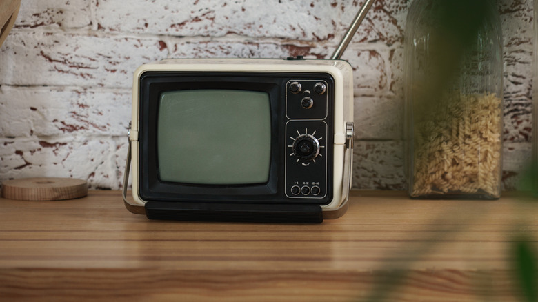A vintage kitchen TV on a wooden countertop