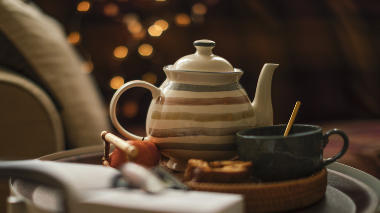 A vintage teapot with a dark blue teacup