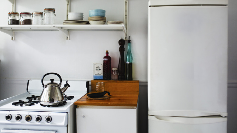 A vintage kitchen with white gas hob and fridge