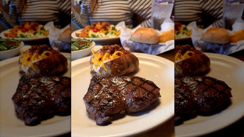 Steak and baked potato on white plate at Texas Roadhouse