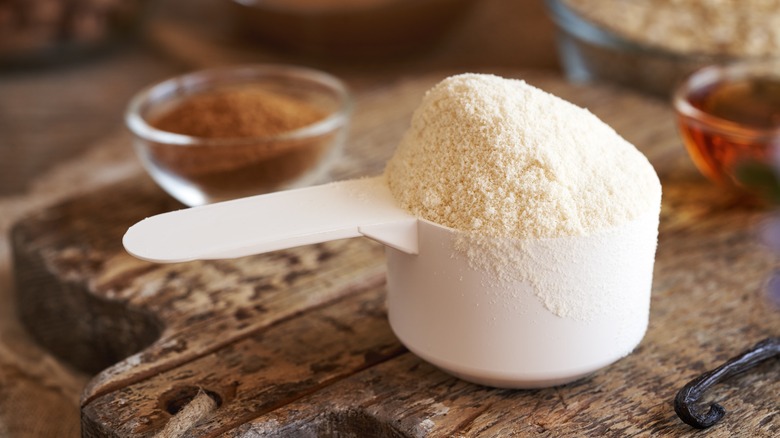 Protein powder in scoop with cinnamon and vanilla