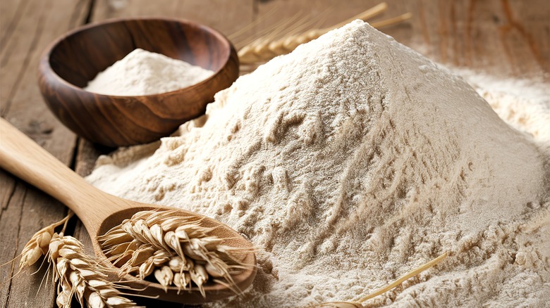 Pile of whole grain flour with bowl