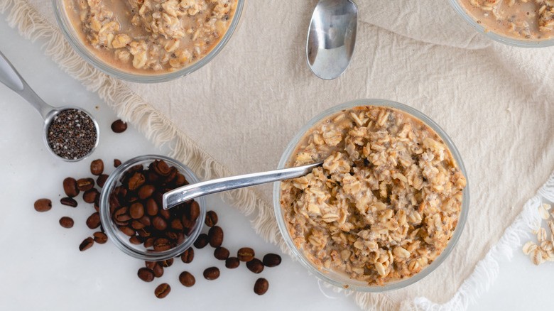 Overhead shot of overnight oats in bowls, alongside coffee beans and chia seeds