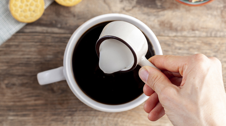 Pouring creamer into coffee