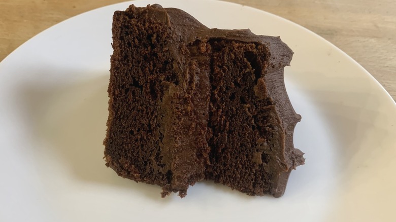 chocolate cake slice on white plate with wood background