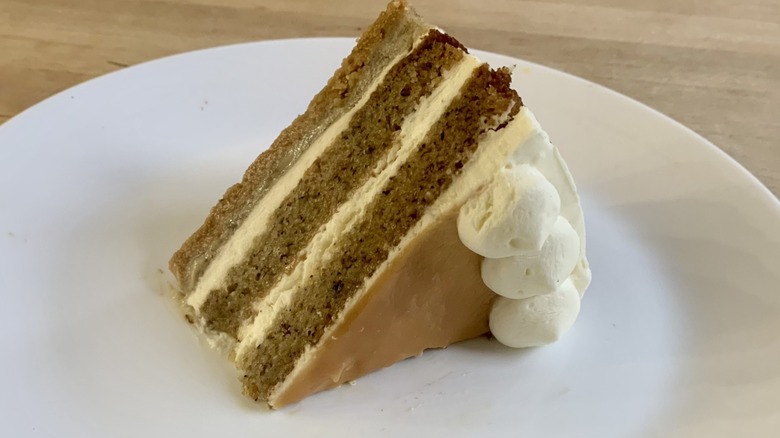 banana cream pie cake slice on white plate with wood background