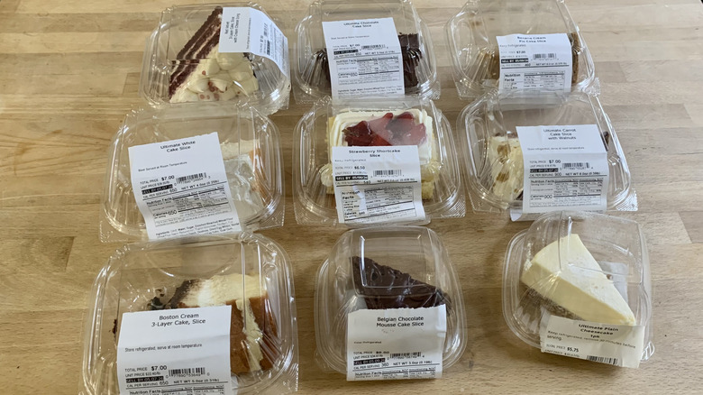 nine cake slices in clear plastic containers on wood background