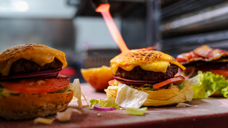 Chef preparing cheeseburgers on counter