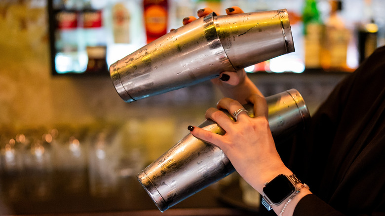 Bartender shaking two cocktails at the same time