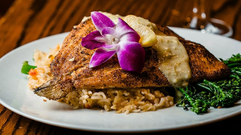 closed up of fish filet over rice served on white plate at Flavor Hills in Raleigh, North Carolina