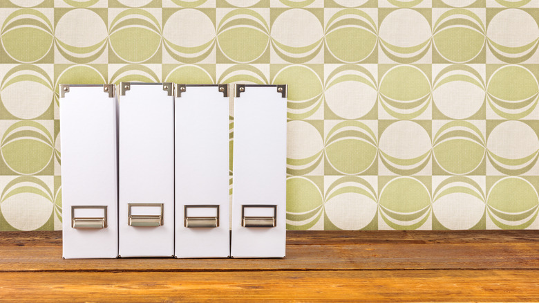 White magazine holders on a wooden surface with a retro background