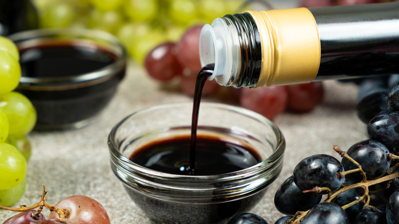 Bowl of balsamic vinegar surrounded by grapes