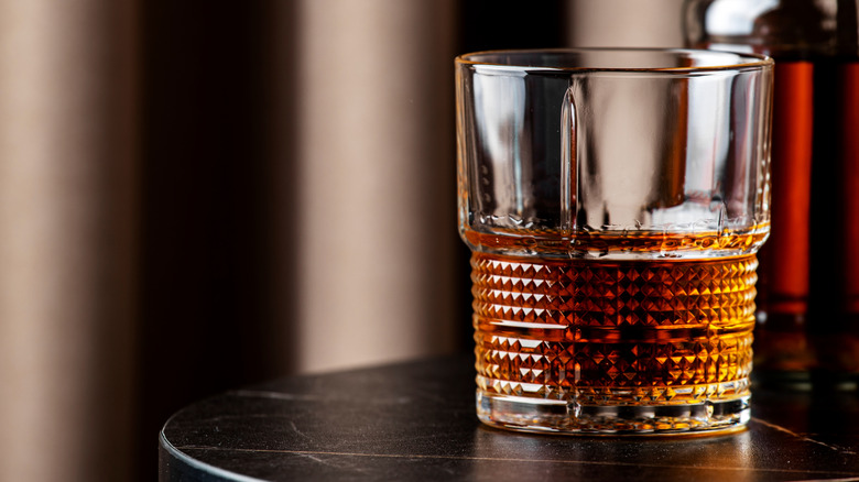 A glass of bourbon on a table