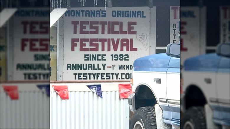 Old sign advertising the Montana Testical Festival, a blue and white truck parked in front of it