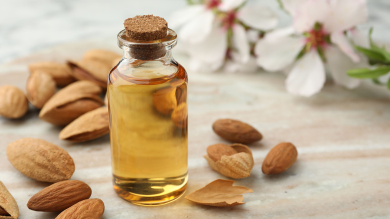 Glass jar of almond extract with whole almond nuts