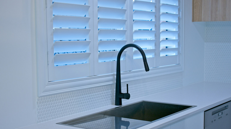Bifold wooden shutters behind a kitchen sink