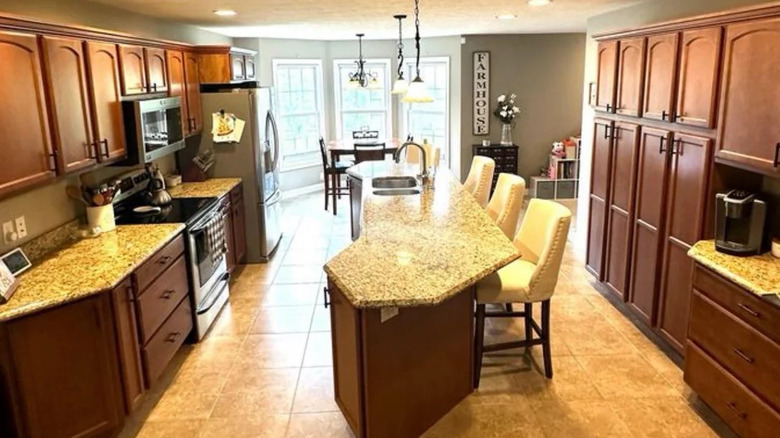 Tuscan-style kitchen with long kitchen island and dark cabinets
