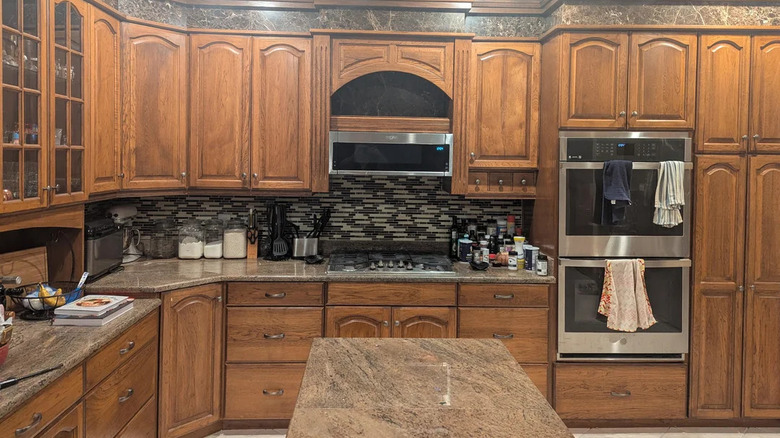 image of dark brown kitchen with wooden cabinets and granite countertops