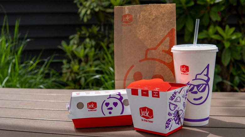 Jack in the Box beverage container, two boxes, and a bag.