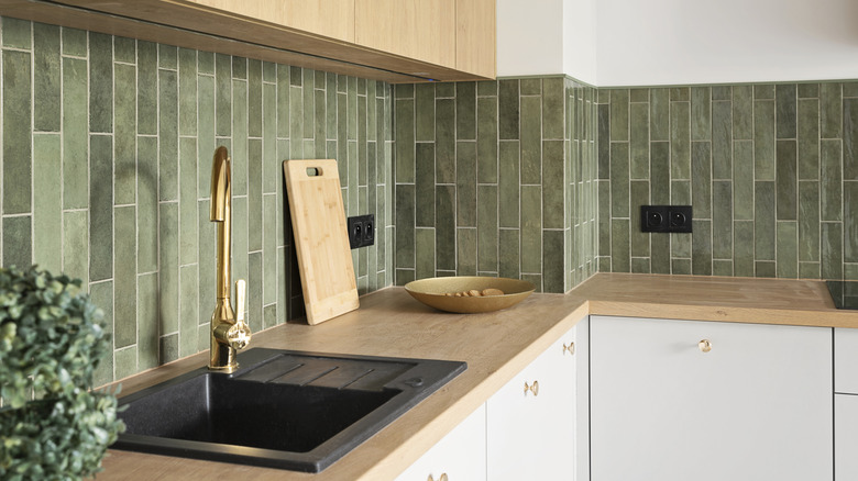 Kitchen backsplash with thin, green tile installed vertically.