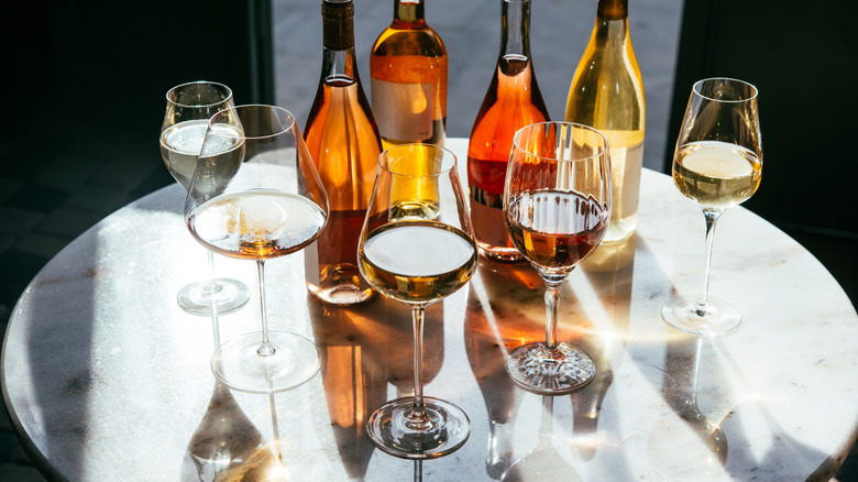 Variety of rose wine bottles and glasses on table