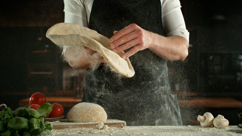 freeze shot of chef making pizza dough