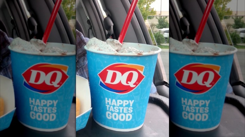 Blue cup of Dairy Queen Drumstick Blizzard dessert inside car