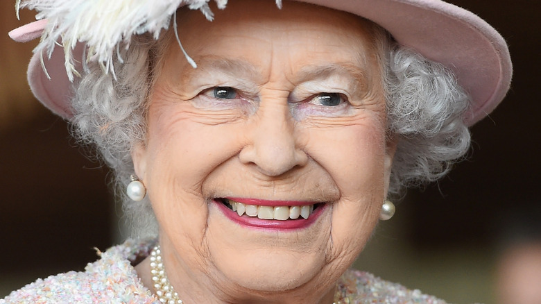 Queen Elizabeth smiling in pink hat