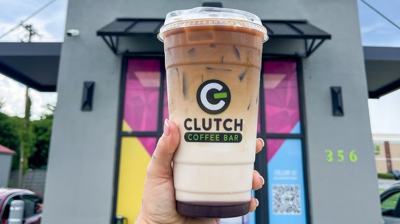 close up of person holding iced coffee from Clutch Coffee Bar