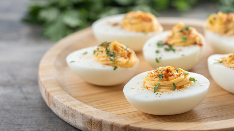 Homemade deviled eggs garnished with herbs.