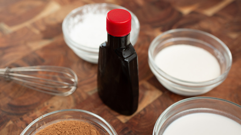 Bottle of vanilla extract surrounded by dry baking ingredients