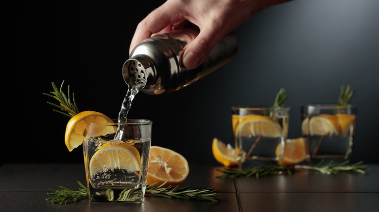 Hand pouring one of three cocktails