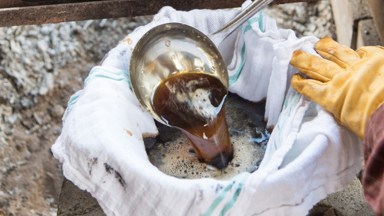 Close up of person filtering maple syrup through a cloth