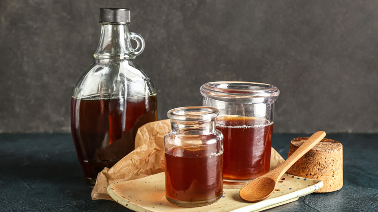 Maple syrup stored in a bottle and different jars
