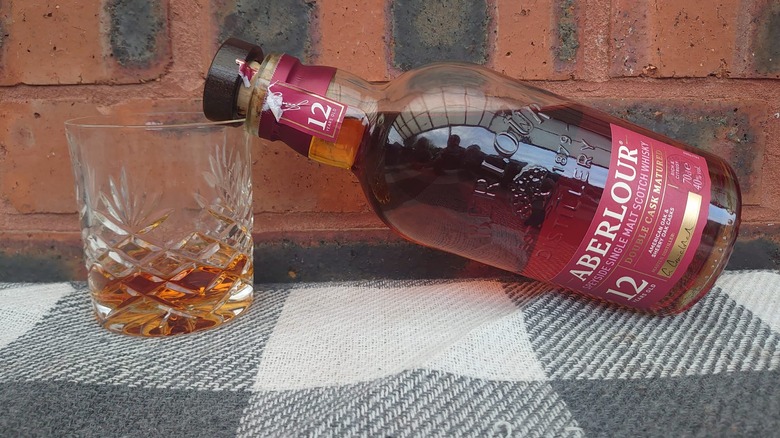 An open bottle of Aberlour 12 resting on a filled crystal tumbler