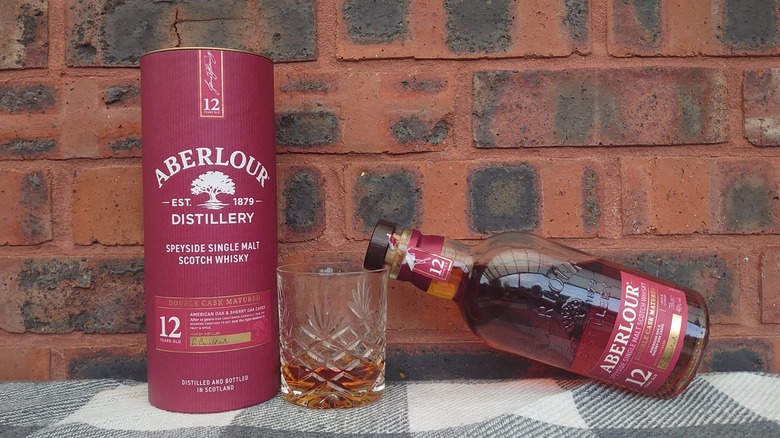 Aberlour's tube packaging shown with its bottle resting on a glass filled with the whisky
