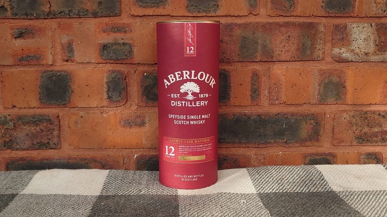 The packaging tube of Aberlour 12 shown on a plain brick background