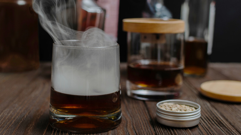 smoky whiskey cocktail next to wood chips