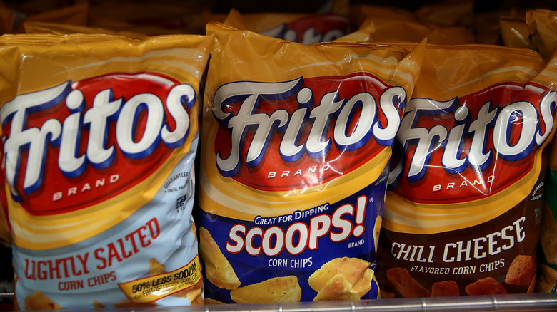 Some different types of Fritos on a shelf.