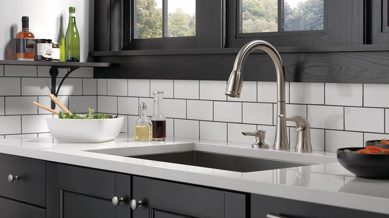 A sink with a Delta Kate Pull-Down Kitchen Faucet