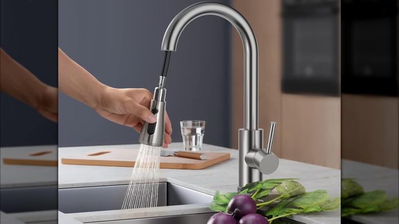A person pulling down the sprayhead on a Forious kitchen faucet