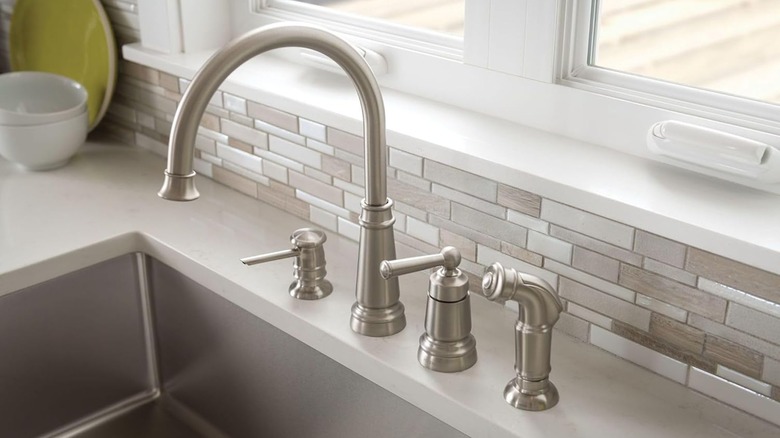 A Moen Edison High Arc Kitchen Faucet with Side Sprayer and Soap Dispenser